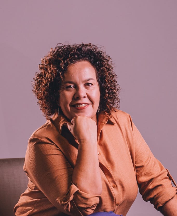 Escuta-qui Pod na imagem Daniela Antunes faz pose com a mão direita segurando o queixo